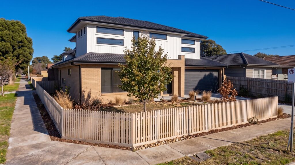 Corner street view of a double storey townhouse in Oakleigh East with an established front garden tree