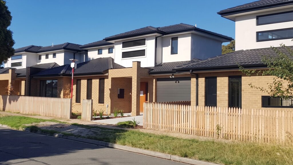 Row of three double storey brick townhouses in Oakleigh East, viewed from the street